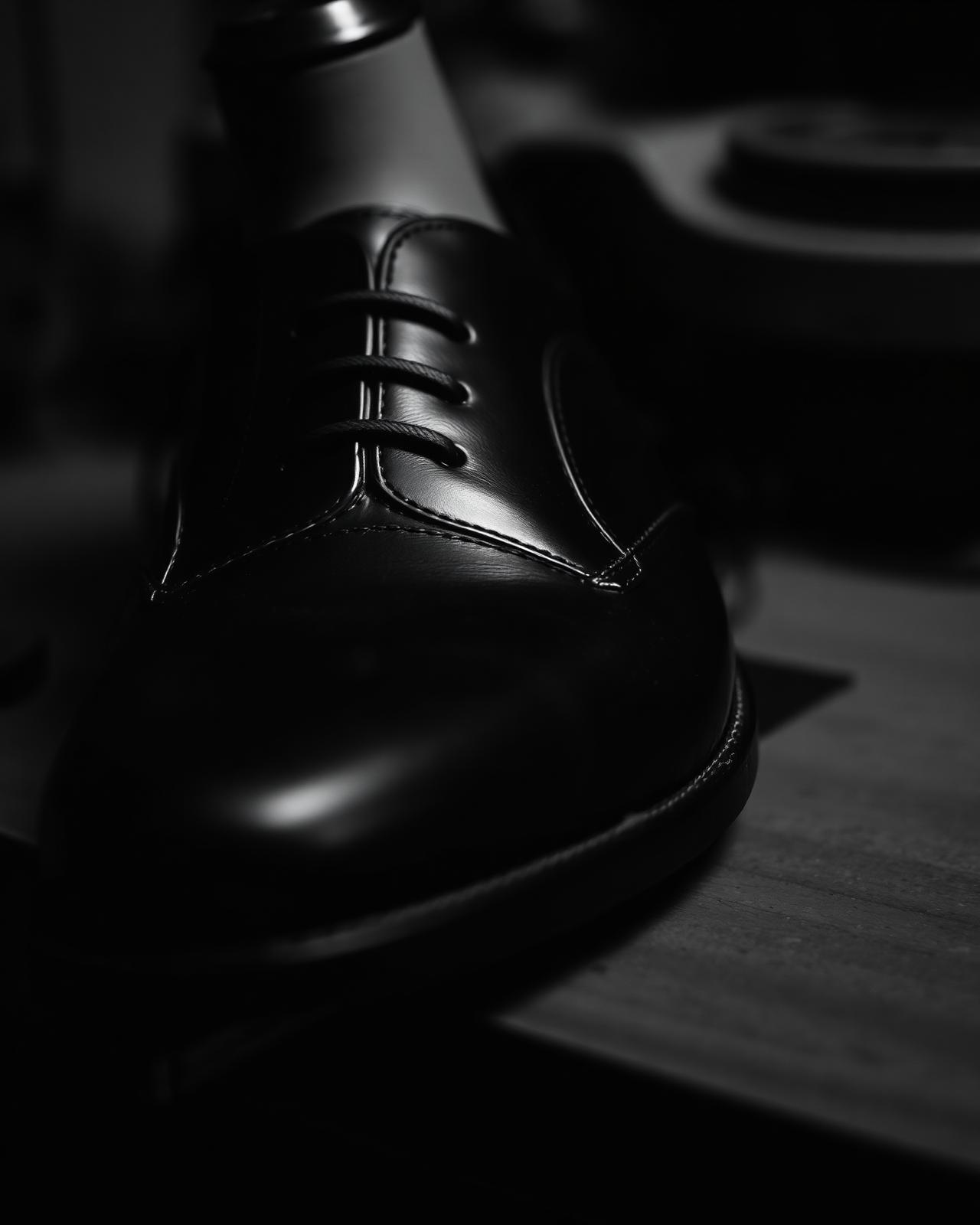 A polished oxford shoe on a wooden last.